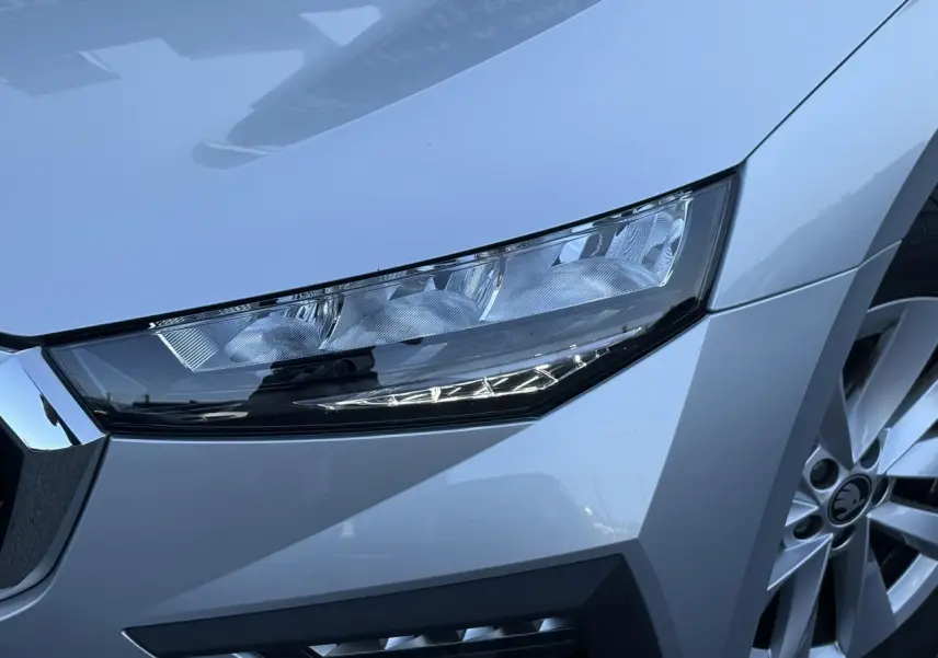 Gros plan sur le phare avant droit et la jante alliage gris Reflex d'une Skoda Scala TSI 116 DSG7 2025.