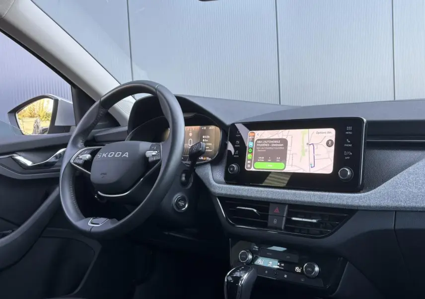 Vue intérieure côté conducteur de la Skoda Scala gris Reflex, avec écran tactile et volant multifonctions en cuir.