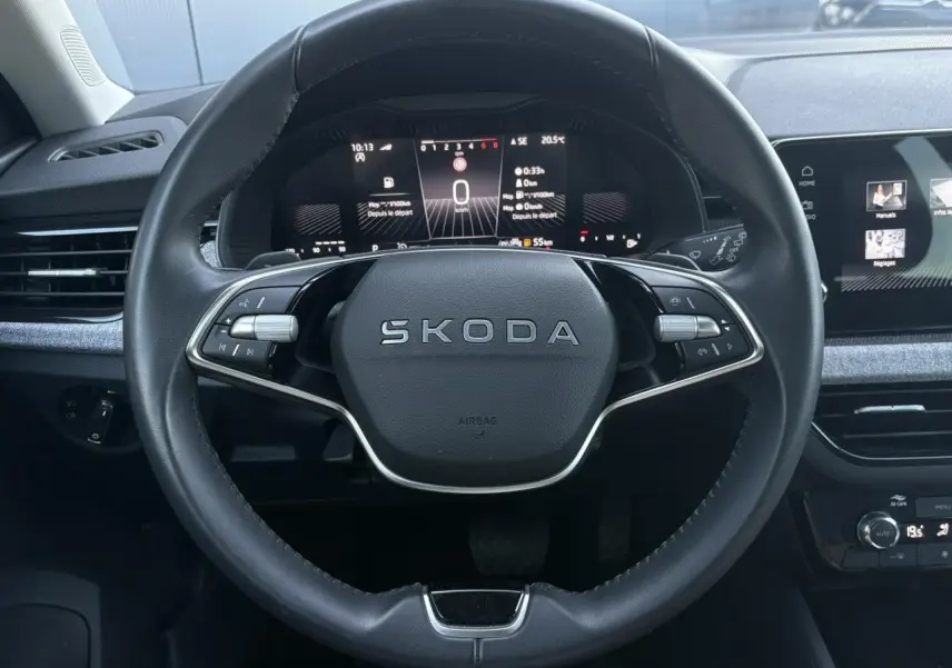Vue frontale du volant en cuir noir avec logo SKODA, tableau de bord digital et écran tactile du Skoda Scala TSI 116 DSG7.