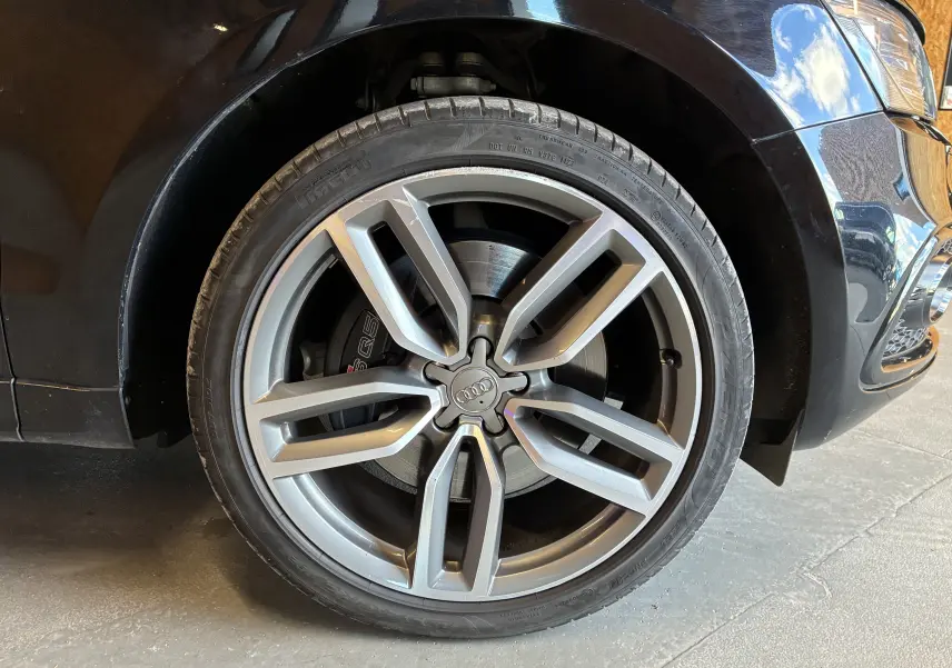 Gros plan sur la roue avant droite noire d’Audi SQ5 3.0 V6 BiTDI avec jante alu à cinq branches doubles.