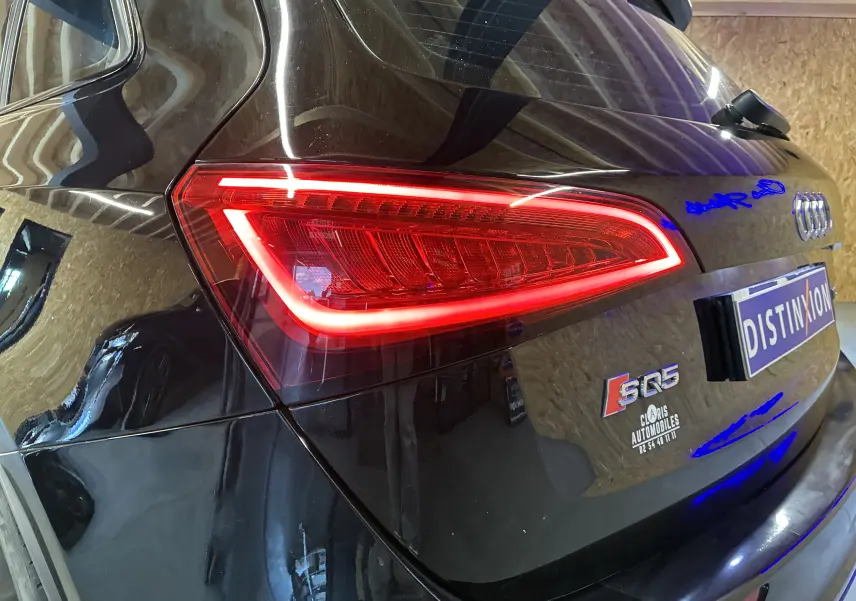 Gros plan sur l'arrière droit noir d'un Audi SQ5 2016 avec feu arrière allumé et badge distinctif visible.