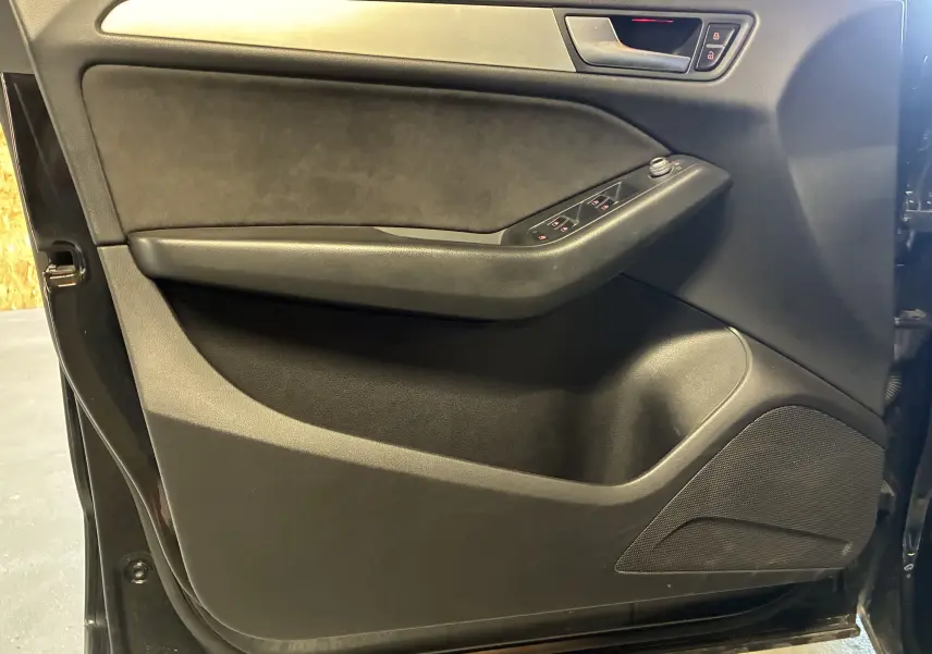Vue intérieure côté gauche de la porte avant noire de l'Audi SQ5 avec commandes de vitres et verrouillage.