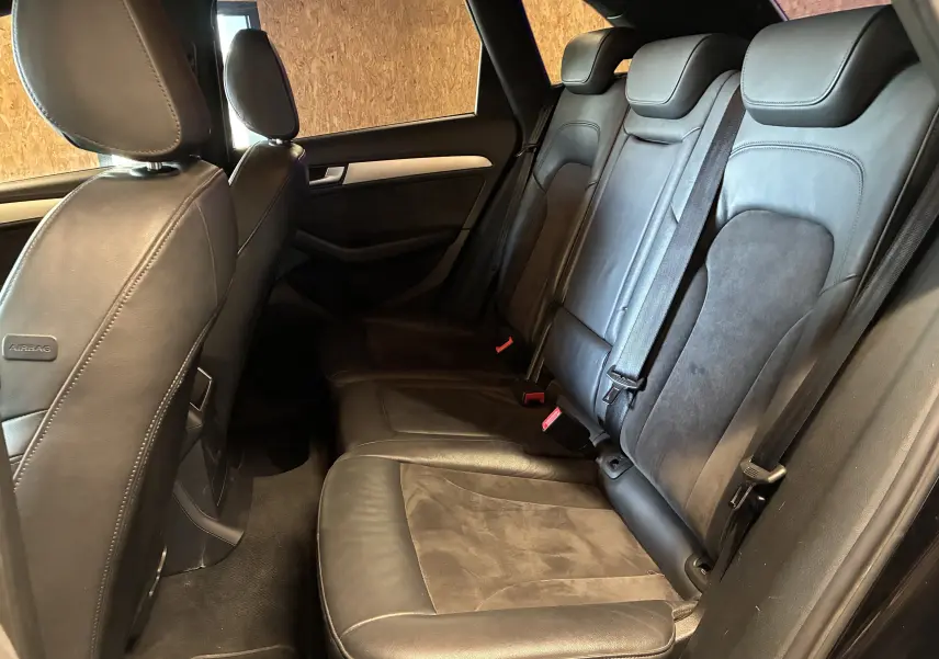 Vue latérale intérieure des sièges arrière en cuir noir de l'Audi SQ5 2016 avec ceintures de sécurité visibles.