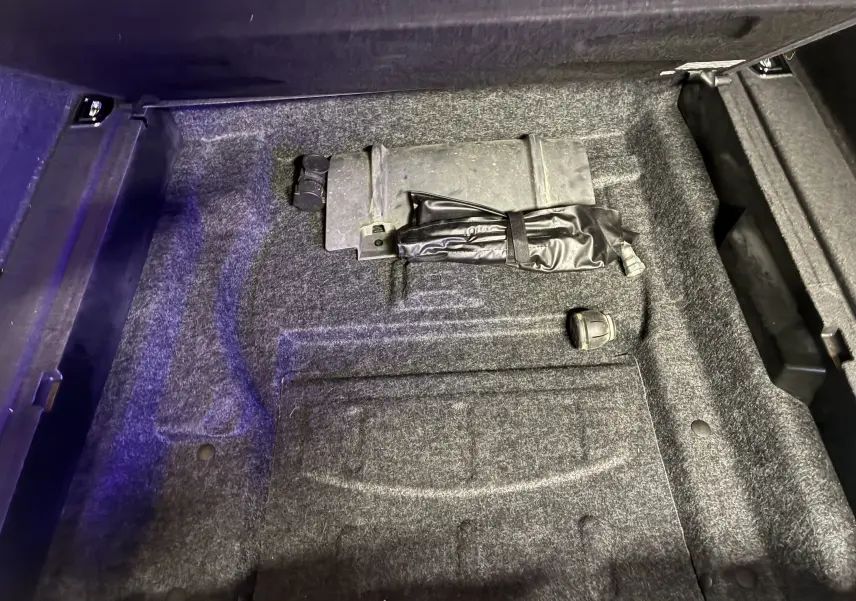 Vue rapprochée du coffre avec tapis gris et kit de réparation pneumatique de l'Audi SQ5 noir 2016.