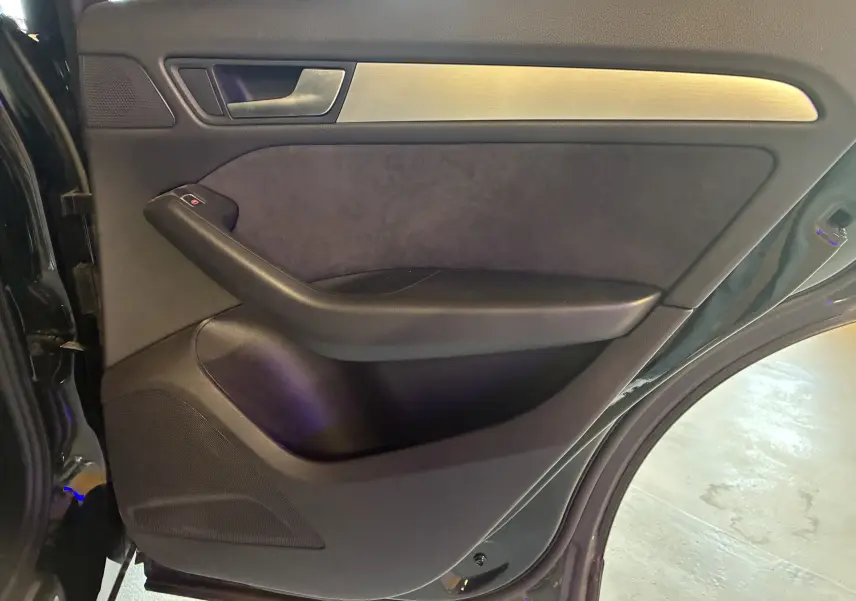 Vue intérieure de la porte arrière droite noire de l'Audi SQ5 2016 avec insert métal et accoudoir en cuir noir.