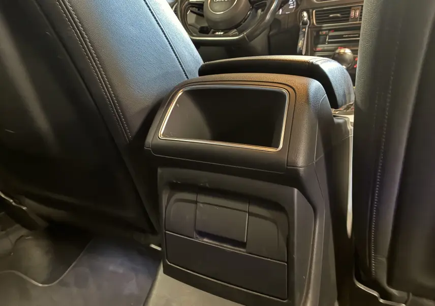 Vue intérieure arrière centrée sur l'accoudoir central noir en cuir entre les sièges avant de l'Audi SQ5.
