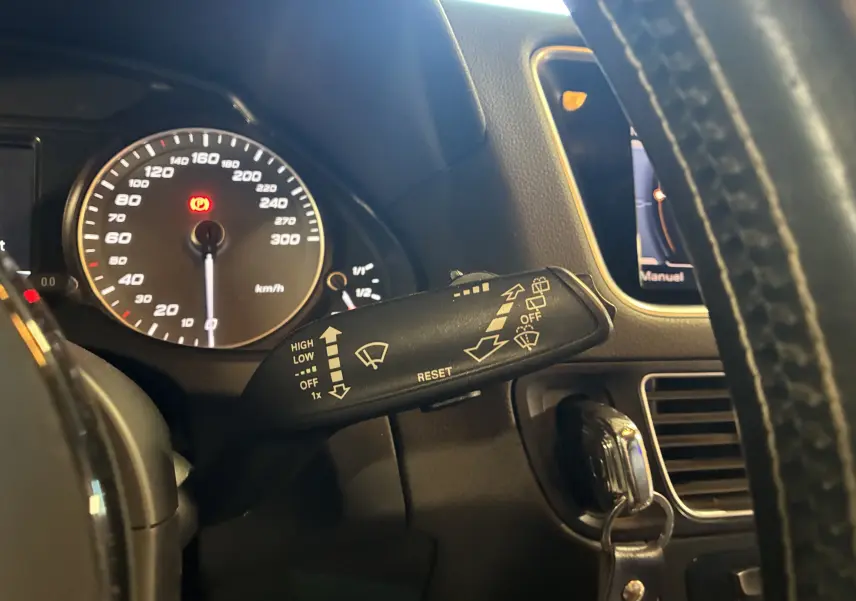 Gros plan sur le commodo de lève-glace et le compteur de vitesse noir de l’Audi SQ5 2016, intérieur noir.