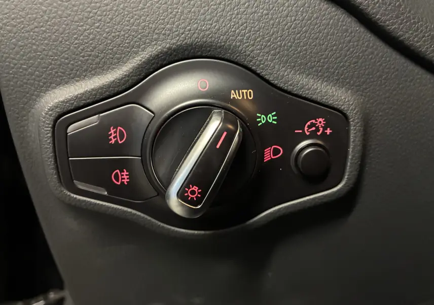 Gros plan sur la commande des phares avec réglages auto et antibrouillard, intérieur noir de l'Audi SQ5 2016.