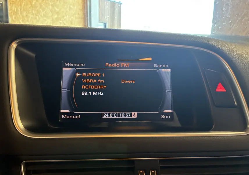 Écran central de l’Audi SQ5 noir affichant la radio FM avec température 24°C et heure 16h57.