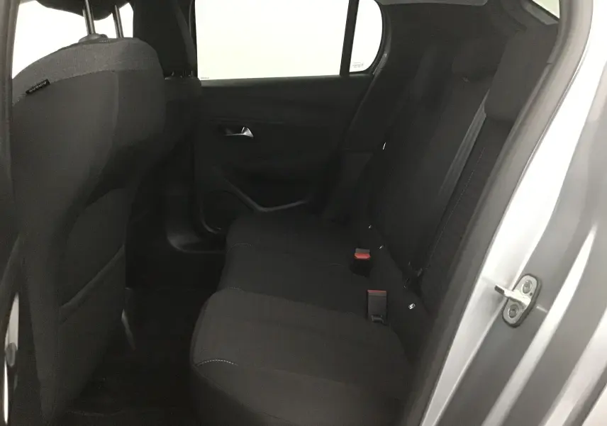 Vue intérieure côté droit sur la banquette arrière noire d'une Peugeot 208 gris Artense 2022 avec porte ouverte.