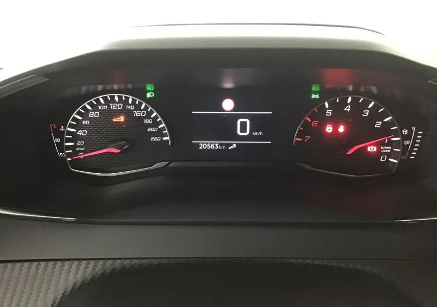 Tableau de bord numérique du Peugeot 208 gris Artense, affichant 20563 km et voyants d'alerte allumés.