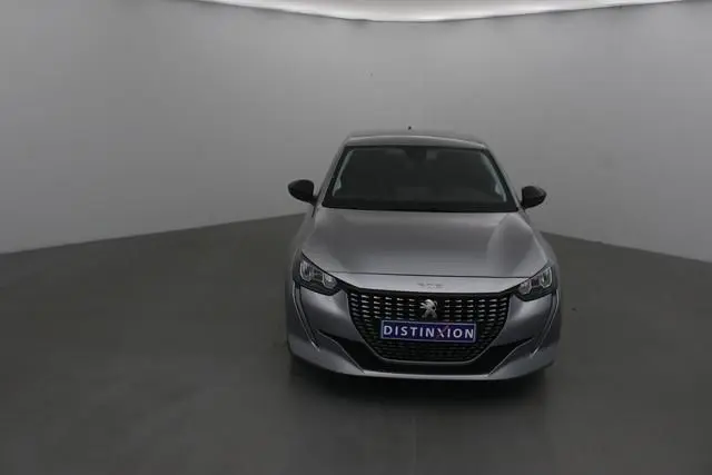 Vue frontale d'une Peugeot 208 gris Artense 2022 avec calandre distinctive et logo lion au centre.
