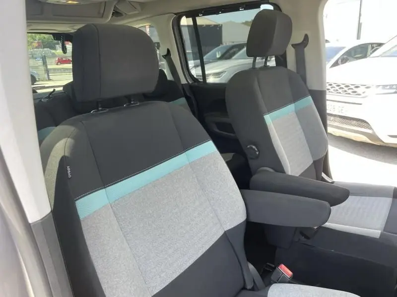 Vue intérieure des sièges avant gris clair et noir avec bande bleue du Citroën Berlingo gris métal 2018 côté droit.