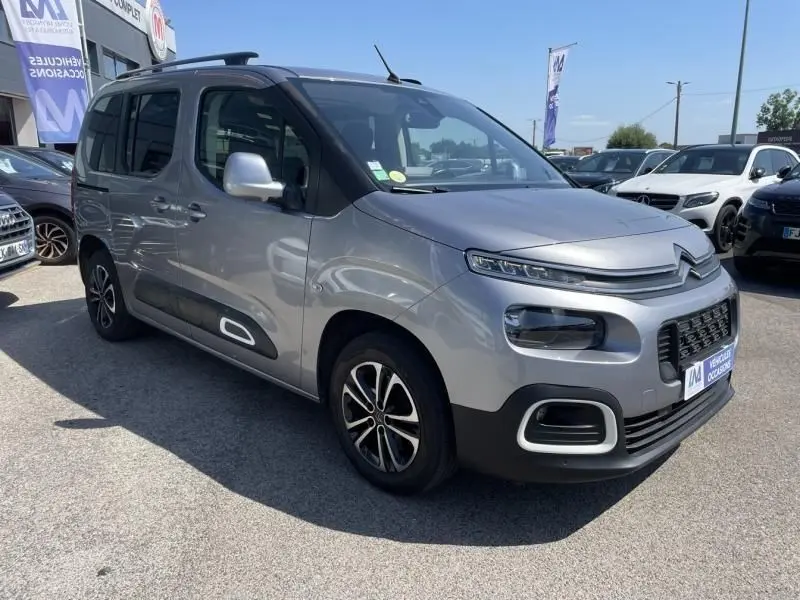 Citroën Berlingo gris métal en 3/4 avant droit, avec protections latérales noires et jantes alliage distinctives.