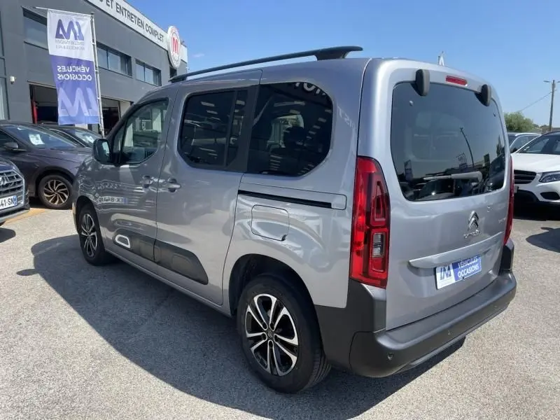 Vue 3/4 arrière droite d'un Citroën Berlingo gris métal 2018 avec vitres teintées et jantes alliage noires.