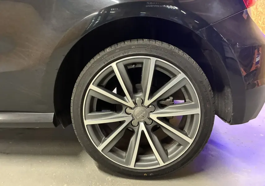 Gros plan sur la roue arrière droite noire d’une Audi A1 2016 avec jante alliage gris à 10 branches.