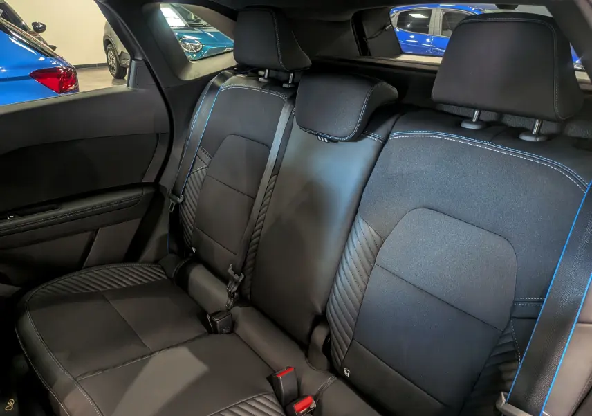 Vue intérieure arrière des sièges noirs en cuir avec surpiqûres bleues du Renault Symbioz E-TECH Full Hybrid 2026.