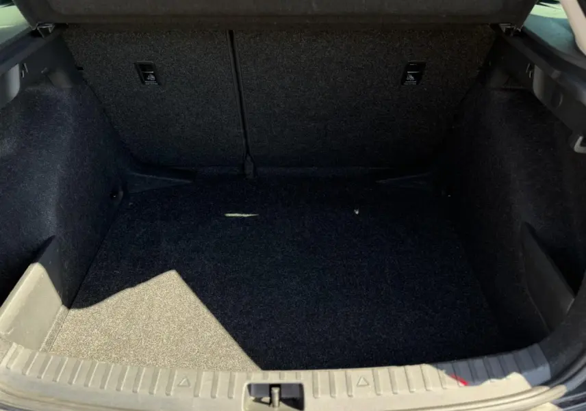 Coffre ouvert de la Skoda Scala TSI 116 DSG7 noir Magic Perle, montrant l'espace de rangement intérieur vide.