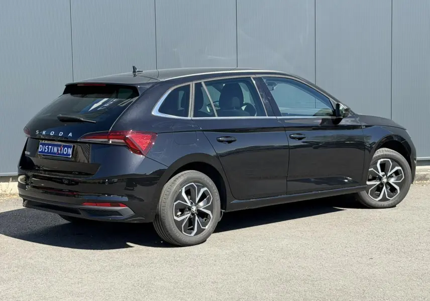 Vue 3/4 arrière droite d'une Skoda Scala noire Magic Perle avec jantes alliage et vitres surteintées.
