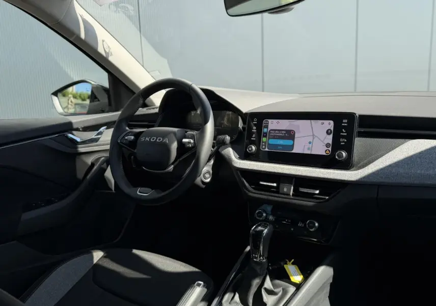 Intérieur de la Skoda Scala TSI 116 DSG7 vu côté conducteur, volant noir et écran tactile central allumé.