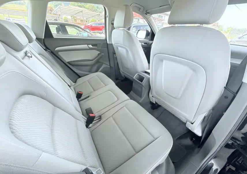 Vue intérieure arrière côté droit montrant les sièges en tissu clair de l'Audi Q5 noir de 2014.