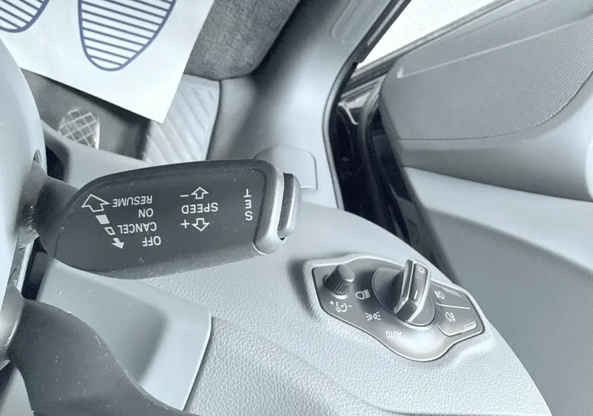 Gros plan sur la commande de régulateur de vitesse et le sélecteur d'éclairage côté gauche de l'Audi Q5 noir.