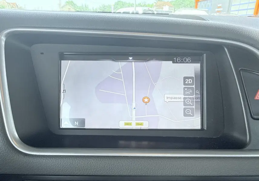 Écran de navigation central de l'Audi Q5 2014 affichant une carte en mode 2D, entouré de tableau de bord noir.