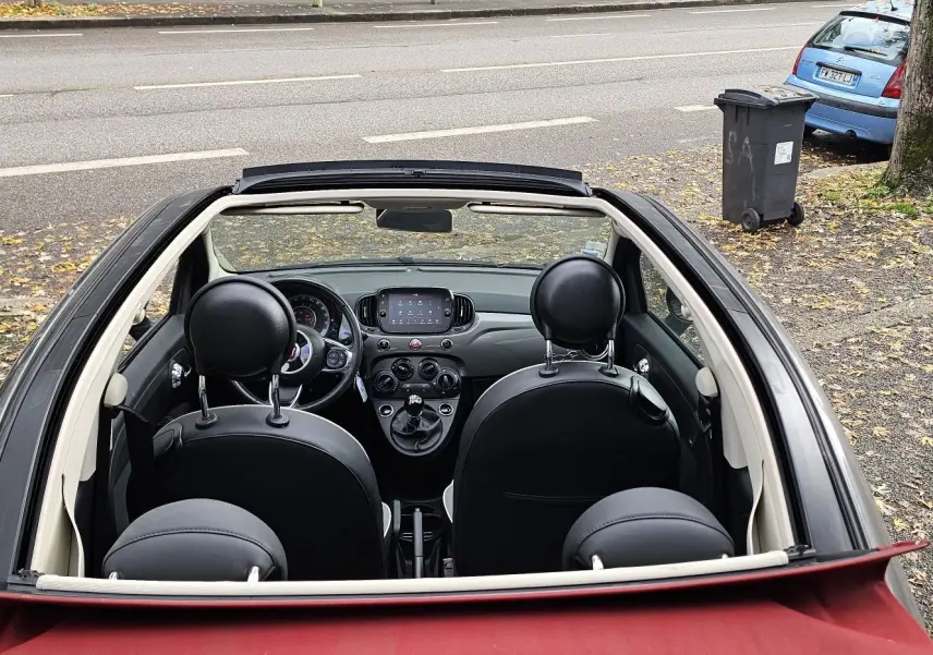 Vue intérieure du tableau de bord et volant d'une Fiat 500C 2019 avec boîte manuelle et finitions noires.