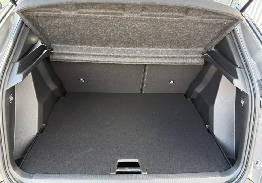 Coffre ouvert vu de l'arrière du Peugeot 2008 gris selenium, montrant un espace de chargement propre et spacieux.
