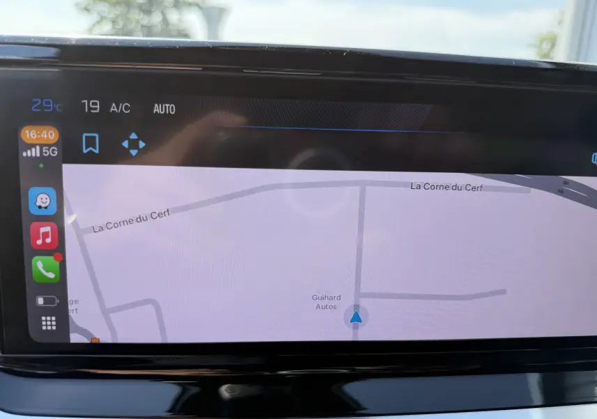 Écran tactile du système de navigation du Peugeot 2008 Hybrid 145ch Allure, affichant une carte et des icônes d'applications.