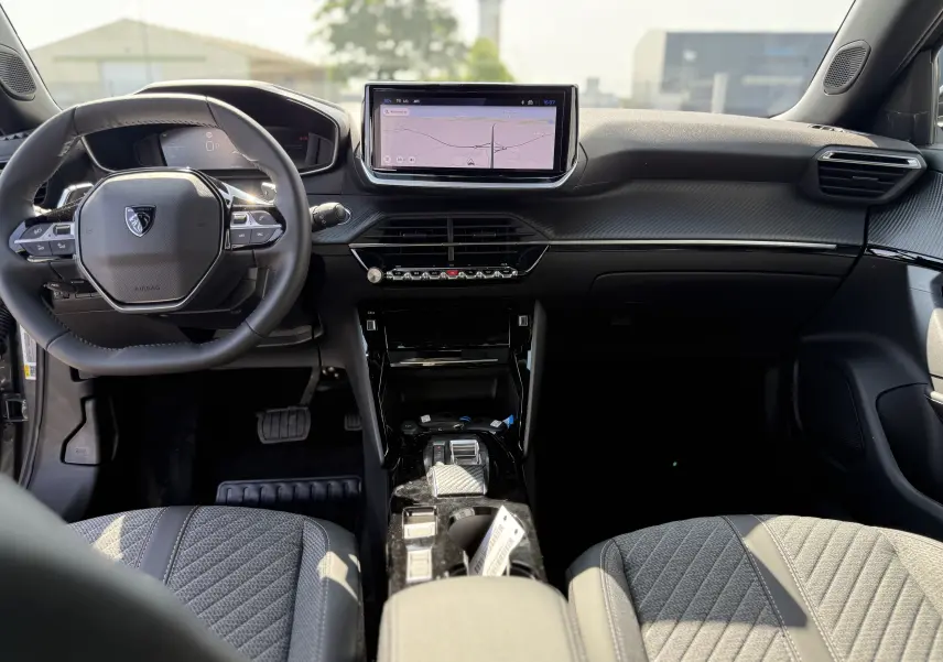 Intérieur du Peugeot 2008 Hybrid 145ch Allure 2025, vue frontale du tableau de bord avec écran tactile et volant compact.