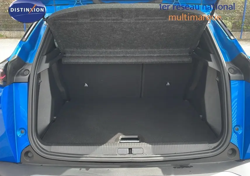 Coffre ouvert en plan rapproché du Peugeot 2008 bleu Vertigo Metal, montrant l'espace de chargement vide.