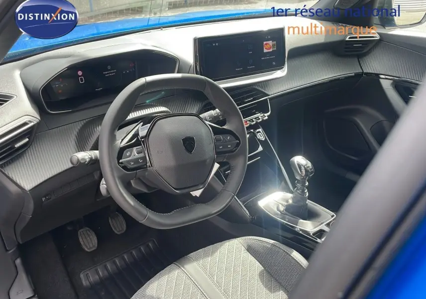 Intérieur du Peugeot 2008 2024 bleu Vertigo, vue côté conducteur sur volant, tableau de bord digital et levier de vitesse manuel.