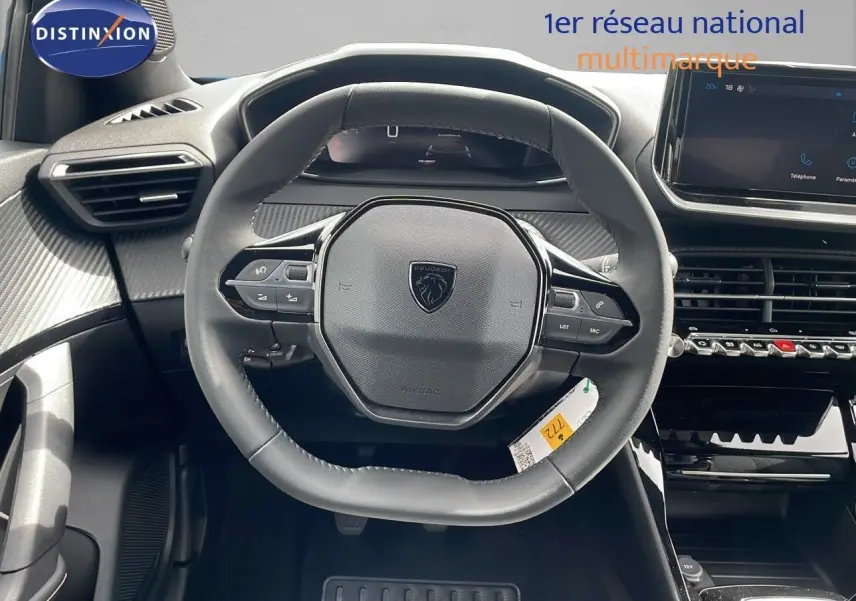 Vue rapprochée du volant cuir noir du Peugeot 2008 2024, avec tableau de bord numérique et écran tactile central.