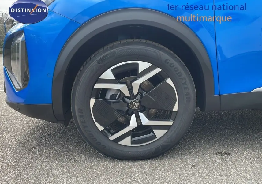 Gros plan sur la roue avant gauche d'un Peugeot 2008 bleu Vertigo Metal avec jante noire et argentée.