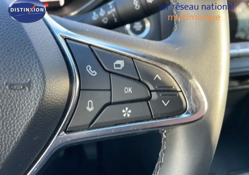 Gros plan sur les commandes au volant à droite du Renault Captur gris Rafale métal avec finition noire intérieure.