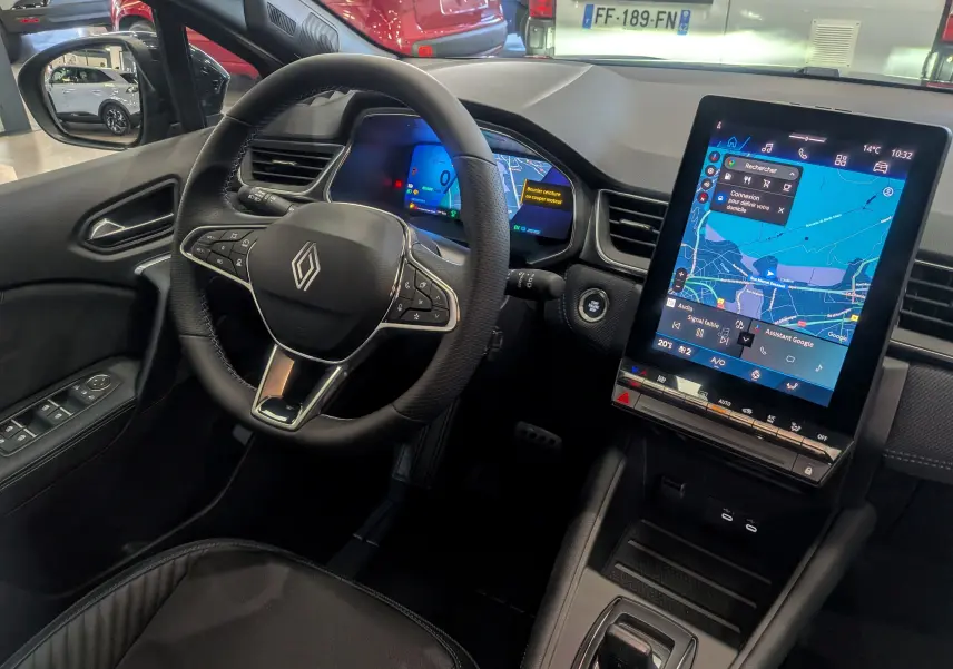 Vue intérieure côté conducteur du Renault Symbioz E-TECH 2026, avec volant noir et grand écran tactile central affichant la navigation.