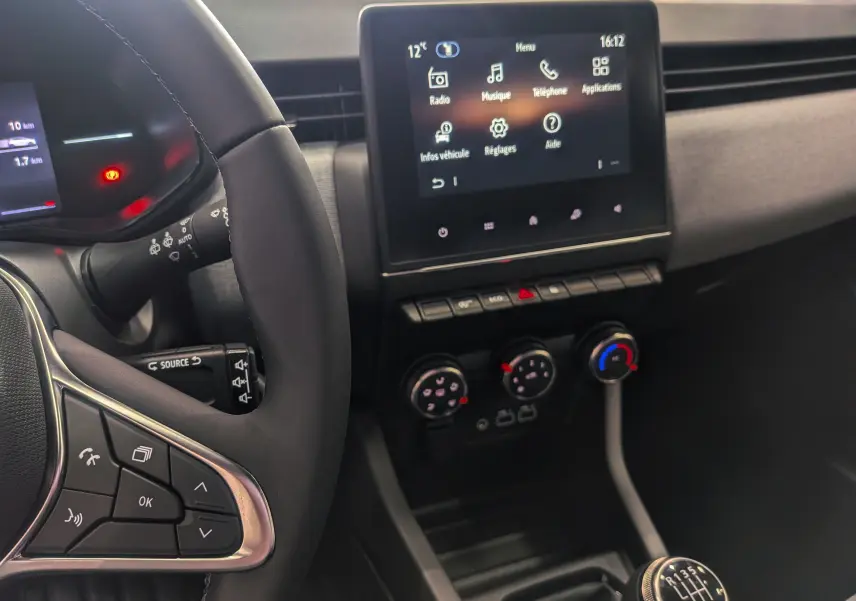 Vue intérieure de la Renault Clio V Blue dCi 100 Evolution montrant le volant, l’écran tactile et la commande de boîte manuelle.