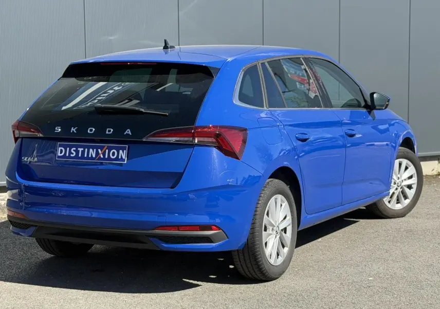 Vue 3/4 arrière droite d'une Skoda Scala TSI 116 DSG7 bleu Energy avec vitres surteintées et jantes alliage 16 pouces.
