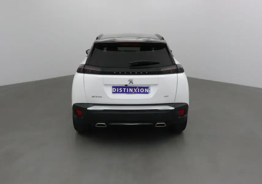 Vue arrière d'un Peugeot 2008 GT blanc nacré avec toit noir, feux sombres et double sortie d'échappement chromée.