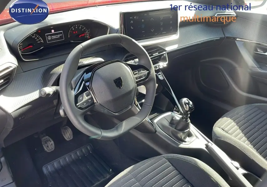 Vue intérieure côté conducteur du Peugeot 2008 2025, montrant volant compact, tableau de bord numérique et levier de vitesse manuel.
