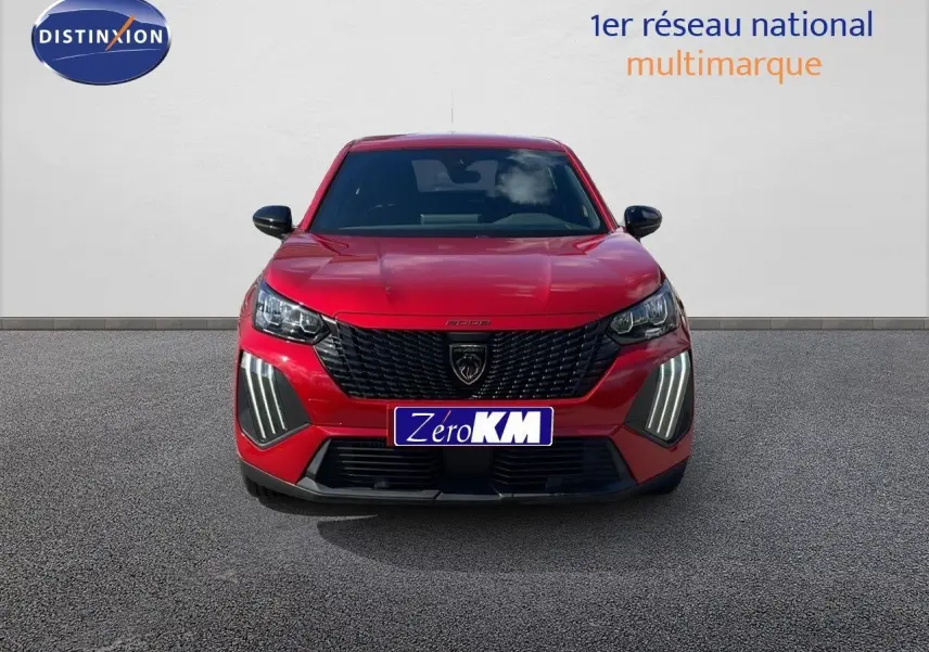 Vue frontale d'un Peugeot 2008 rouge Elixir Metal avec calandre noire et feux LED distinctifs allumés.