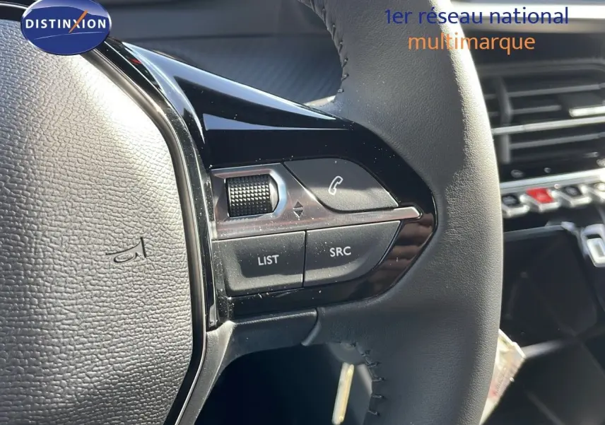 Gros plan sur le volant du Peugeot 2008 2025 avec commandes audio intégrées et finition noire élégante.