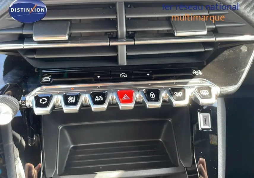 Gros plan sur la console centrale du Peugeot 2008 rouge Elixir Metal, montrant les commandes climatisation et boutons fonctionnels.