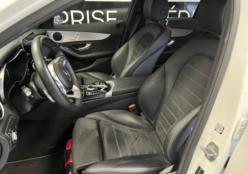 Intérieur noir cuir AMG de la Mercedes Classe C Break C 300 e vu côté conducteur avec volant multifonction et console centrale.