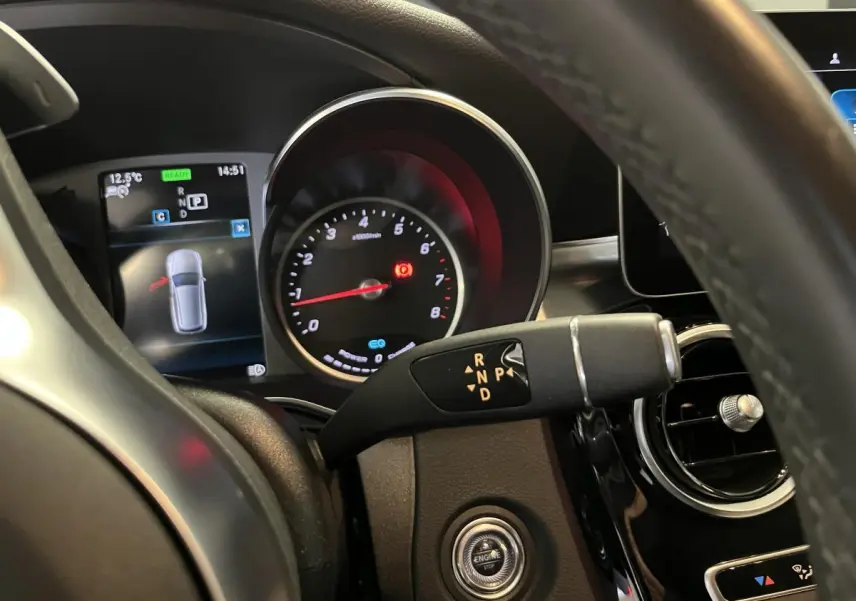 Gros plan intérieur sur le tableau de bord et levier de vitesses de la Mercedes Classe C Break blanc hybride 2019.