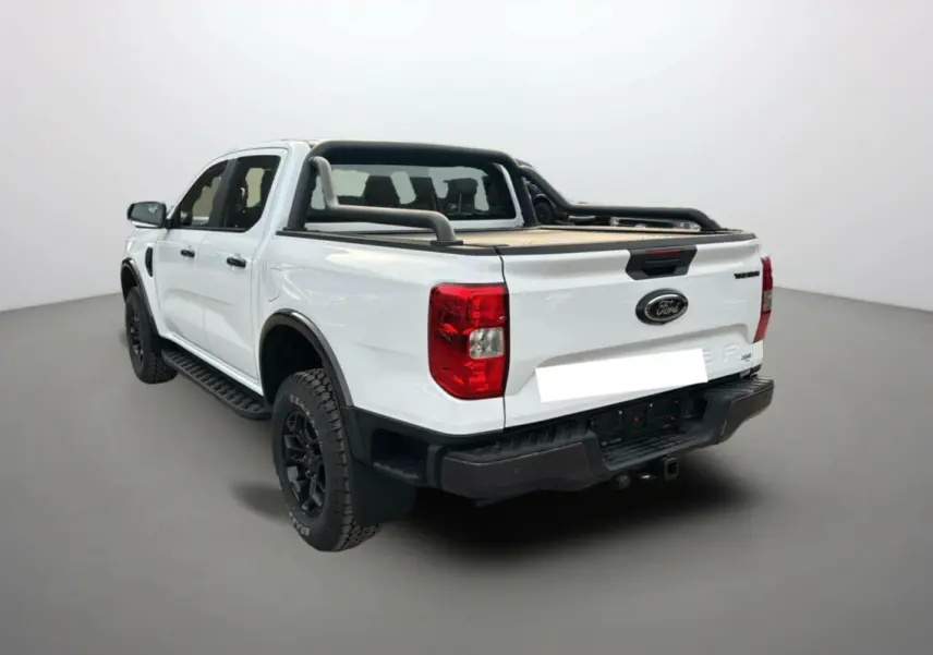 Ford Ranger blanc glacier en 3/4 arrière droit avec arceaux noirs et benne couverte sur fond neutre.