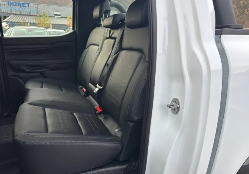 Vue latérale intérieure montrant la banquette arrière en cuir noir du Ford Ranger blanc glacier 2025 double cabine.