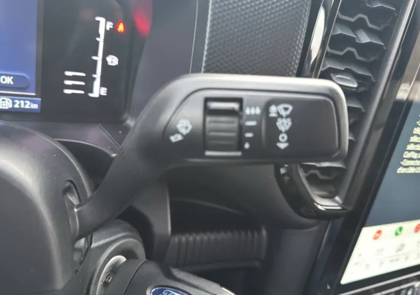 Gros plan sur la commande d'essuie-glace et le tableau de bord numérique du Ford Ranger blanc glacier 2025.