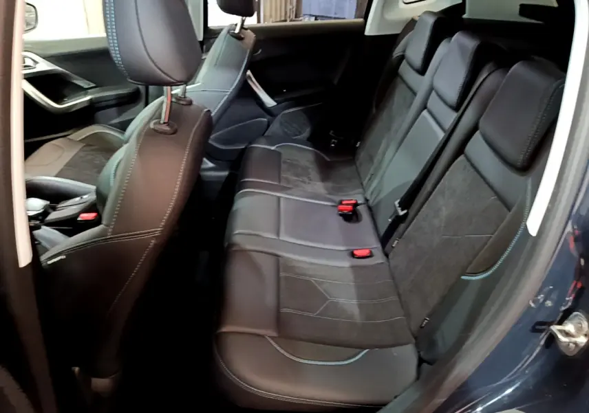 Vue intérieure côté droit montrant la banquette arrière en cuir noir et tissu gris du Peugeot 2008 gris foncé de 2019.